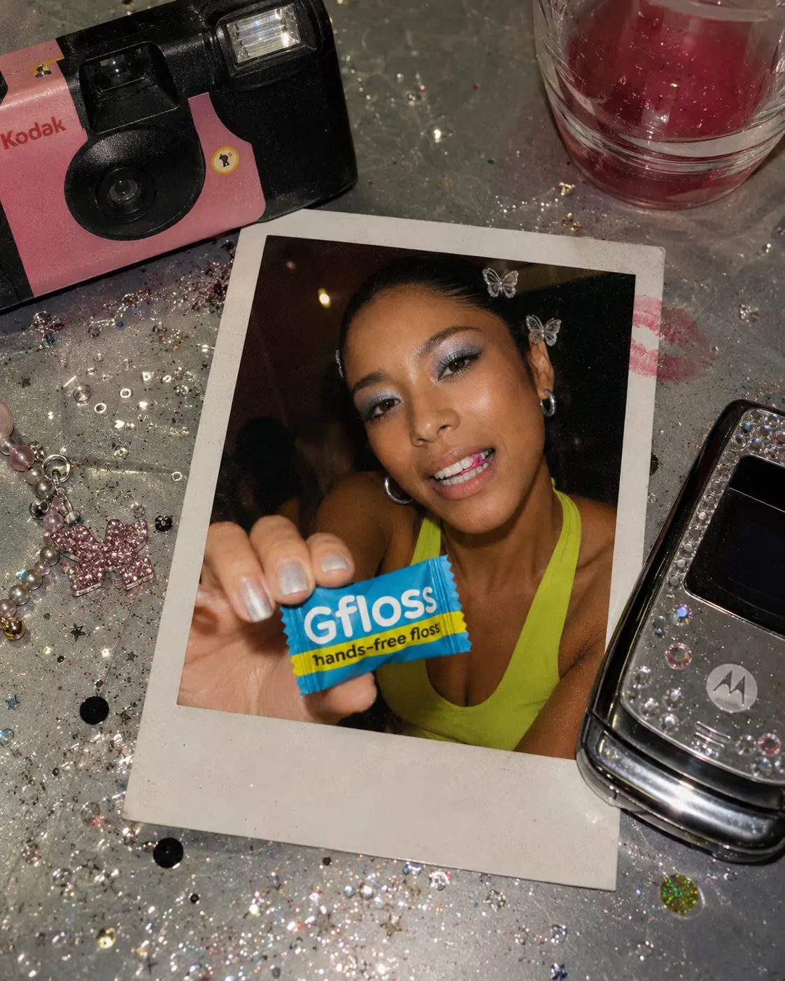 Woman holding a Gfloss hands-free dental floss packet to show an easy daily flossing habit.